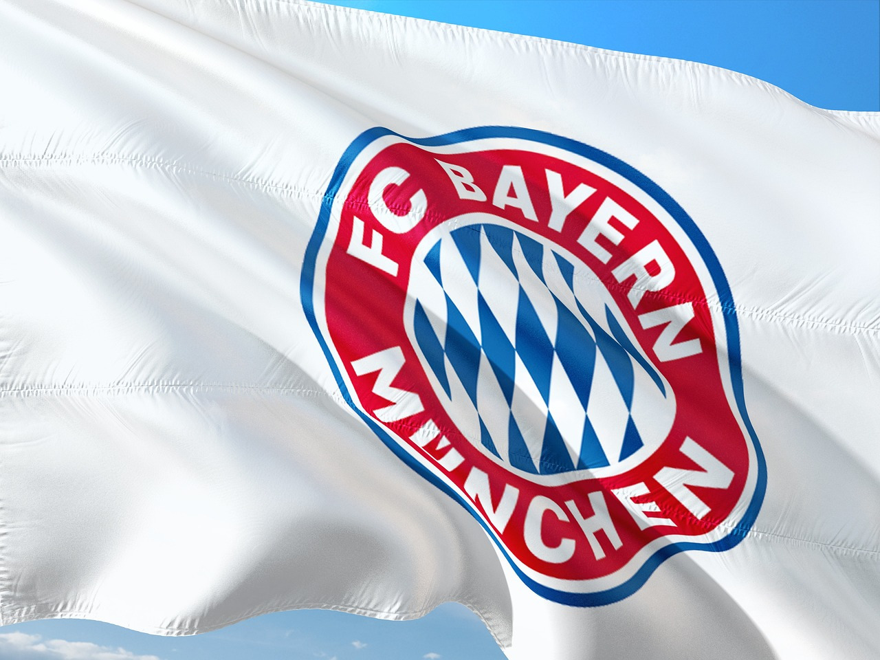 Eine Fahne des FC Bayern München weht im Wind.